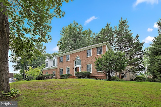 colonial house featuring a front lawn