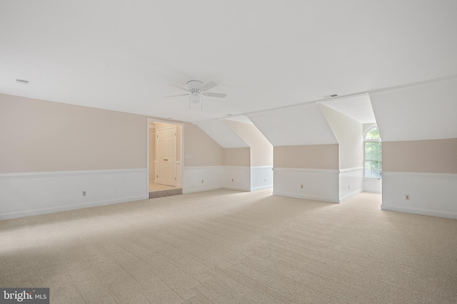 additional living space featuring light carpet, vaulted ceiling, and ceiling fan