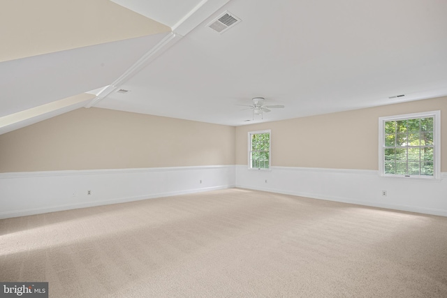 unfurnished room featuring a healthy amount of sunlight, light carpet, and ceiling fan