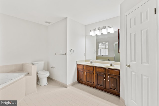 bathroom with vanity, toilet, tile patterned flooring, and tiled tub