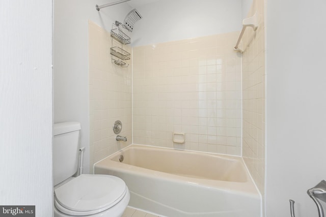 bathroom featuring tiled shower / bath combo and toilet