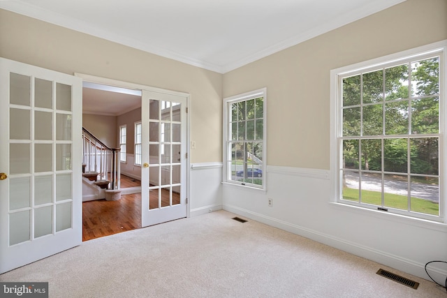 empty room with ornamental molding, carpet flooring, and french doors