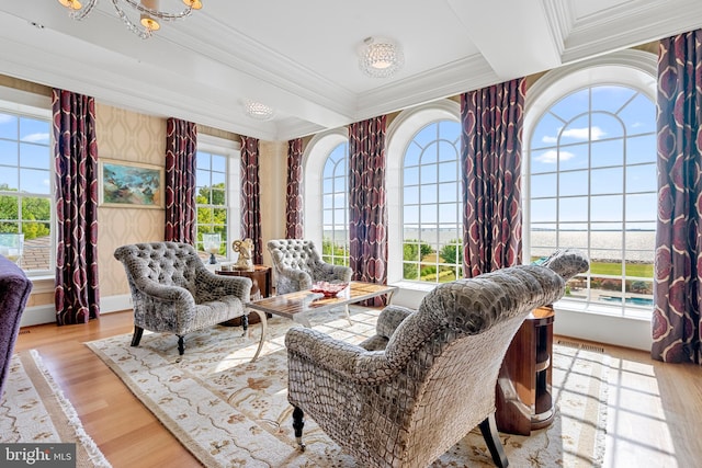 sitting room with crown molding and light hardwood / wood-style flooring