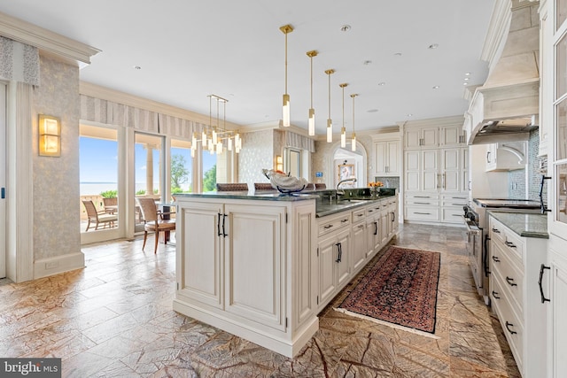 kitchen with high end stainless steel range oven, a large island, ornamental molding, pendant lighting, and sink