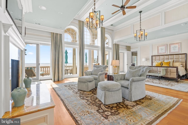 interior space with hardwood / wood-style floors, a high ceiling, access to outside, a chandelier, and ornamental molding