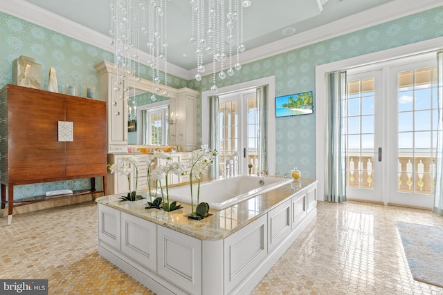 bathroom with an inviting chandelier, ornamental molding, french doors, and a tub