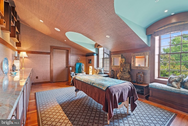 bedroom with hardwood / wood-style floors and lofted ceiling