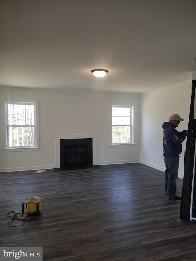 unfurnished living room featuring dark wood-type flooring