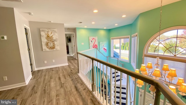 corridor featuring a notable chandelier and hardwood / wood-style flooring