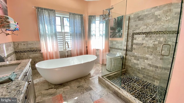 bathroom featuring vanity, shower with separate bathtub, and tile walls