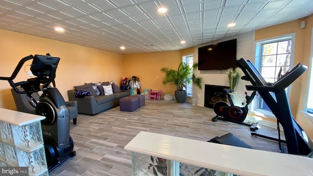 workout room with light wood-type flooring and a large fireplace