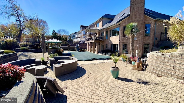 view of property's community with a wooden deck, a gazebo, and a patio area