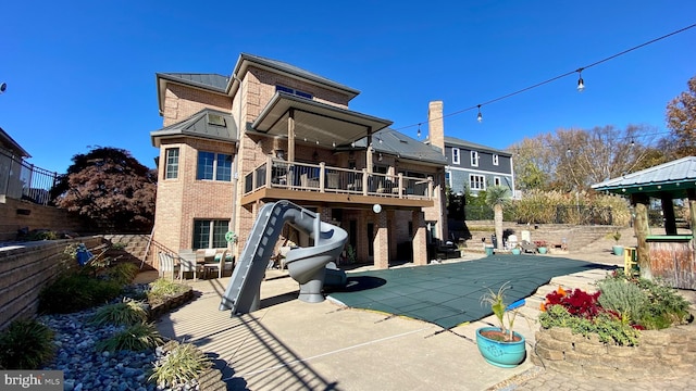 rear view of property with a patio and a pool side deck