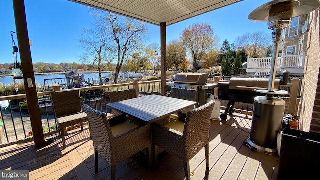 deck with grilling area and a water view