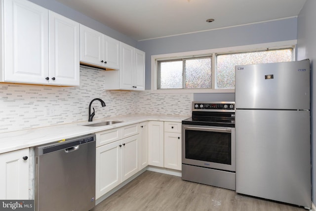 kitchen featuring light hardwood / wood-style flooring, white cabinetry, sink, and stainless steel appliances