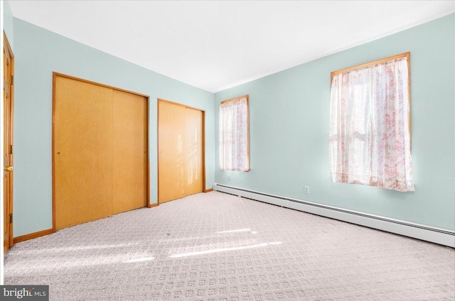 unfurnished bedroom with a baseboard radiator and carpet