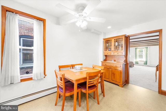 carpeted dining area with ceiling fan and baseboard heating