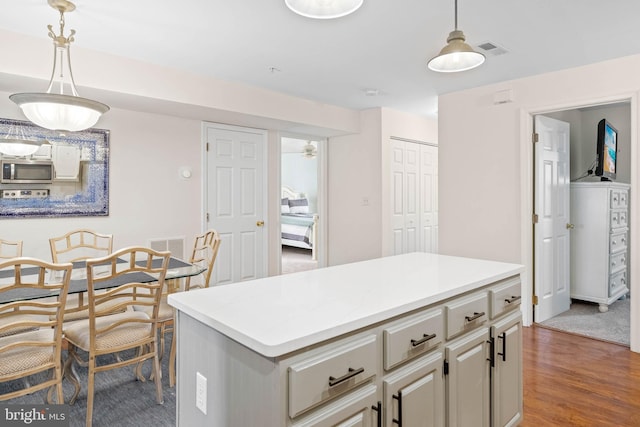 kitchen with dark hardwood / wood-style flooring, decorative light fixtures, range, and a center island