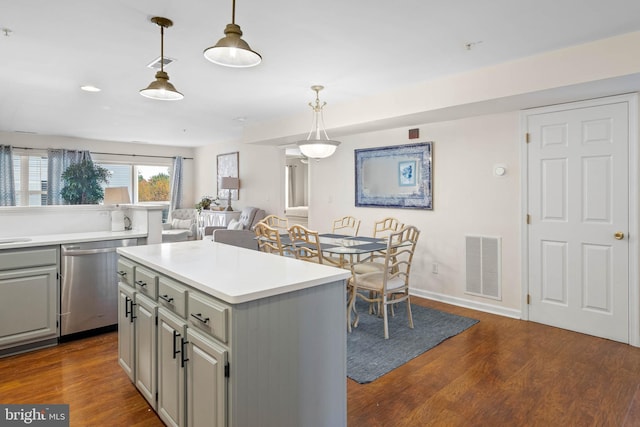 kitchen with dark hardwood / wood-style flooring, decorative light fixtures, dishwasher, and gray cabinets