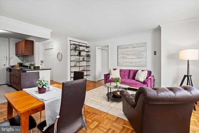 living room featuring ornamental molding, sink, and light parquet flooring