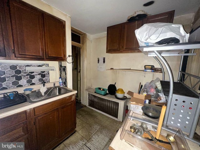 kitchen featuring light countertops, a sink, and decorative backsplash