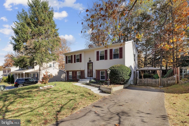 split foyer home featuring a front lawn and a carport