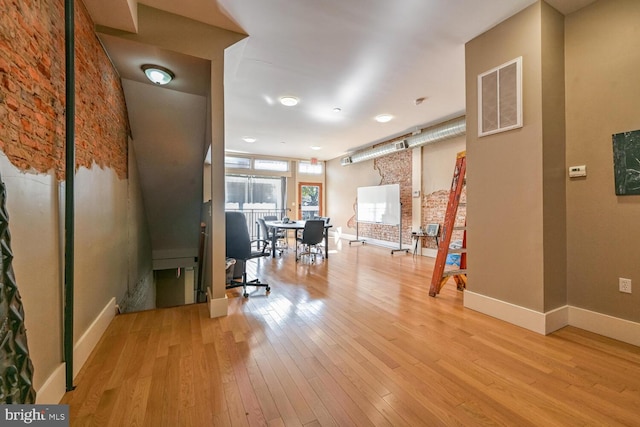 interior space featuring brick wall and light wood-type flooring