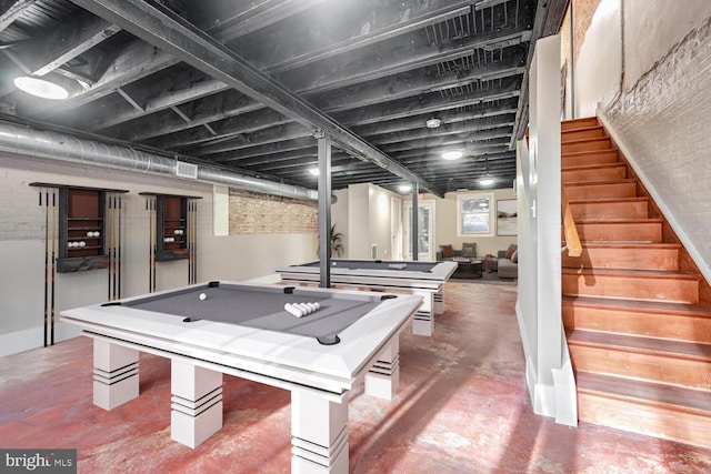 rec room featuring concrete floors, billiards, and brick wall