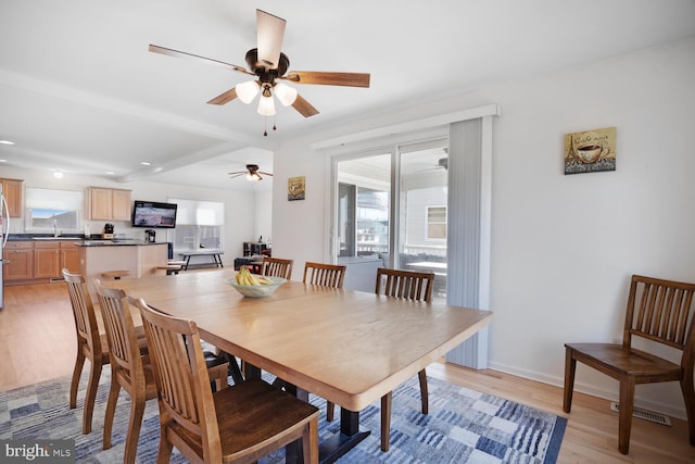 dining room with light wood-type flooring, ceiling fan, and sink