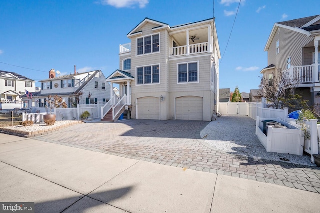 view of front of property with ceiling fan, a garage, and a balcony