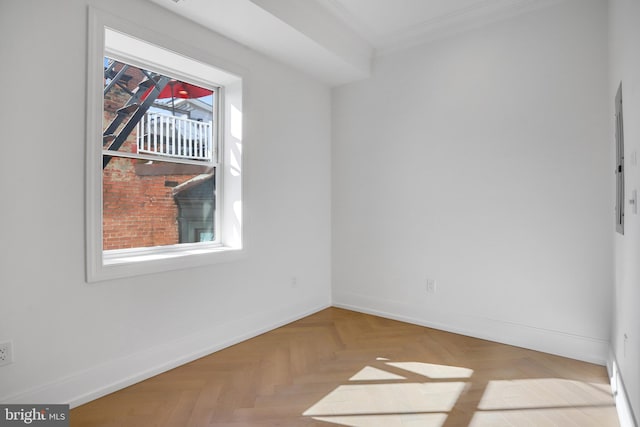 empty room with parquet flooring, a healthy amount of sunlight, and crown molding