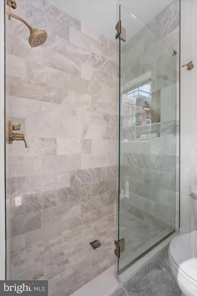 bathroom featuring toilet and an enclosed shower