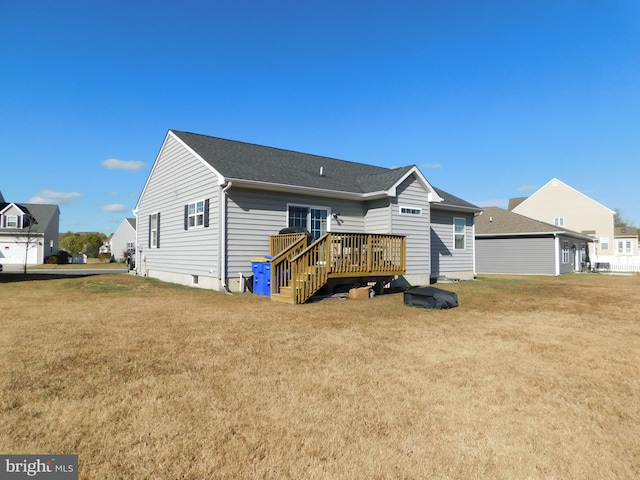 back of property featuring a wooden deck and a lawn