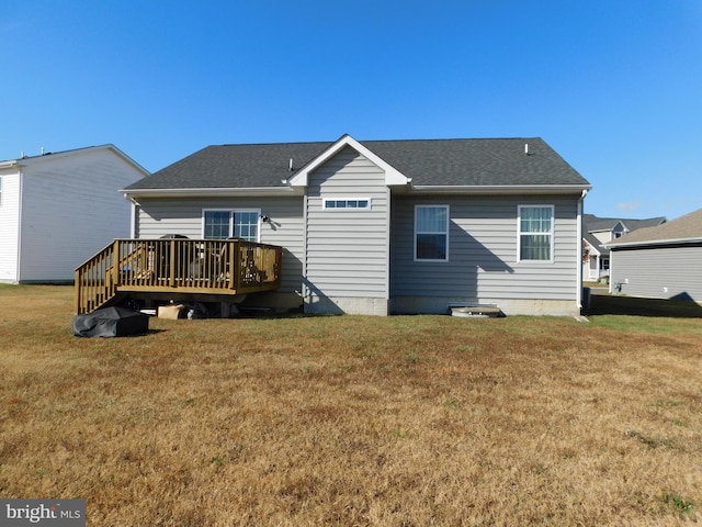 back of property with a yard and a wooden deck