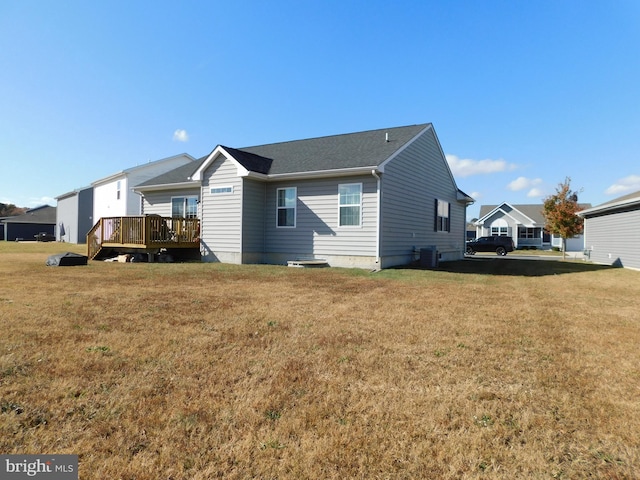 back of property with central AC, a lawn, and a deck