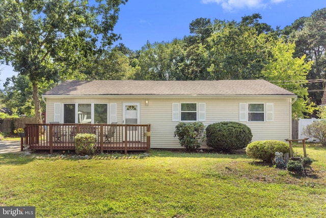 view of front of property with a front yard and a deck