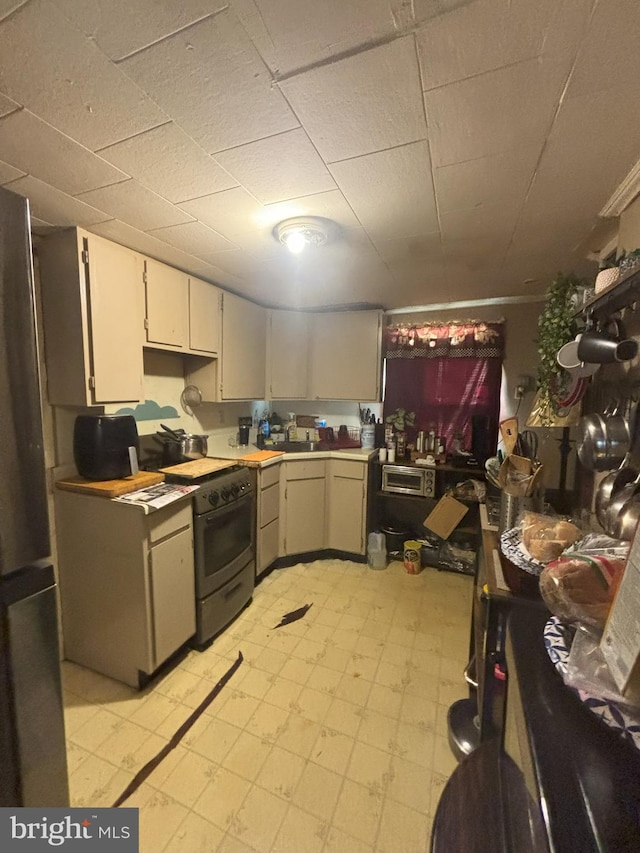 kitchen with range with gas cooktop, stainless steel refrigerator, and sink