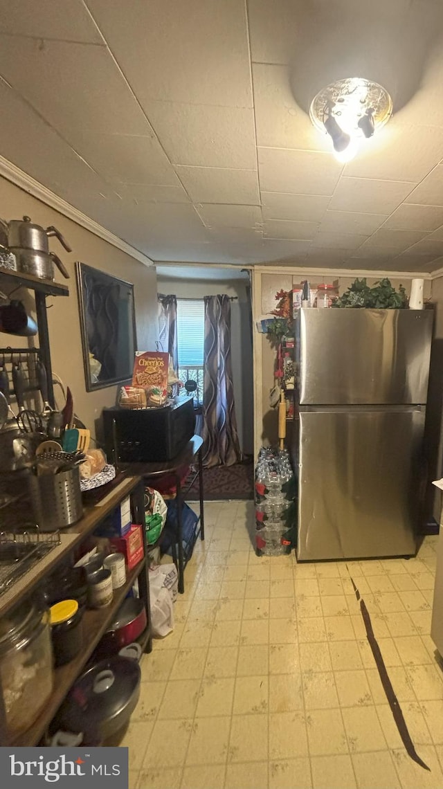 kitchen featuring stainless steel refrigerator and ornamental molding