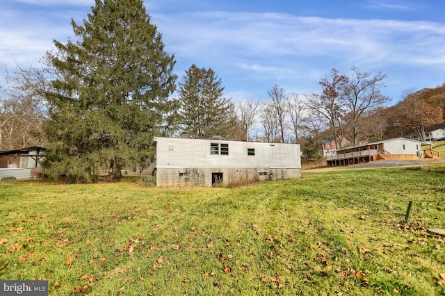 rear view of house featuring a deck and a yard