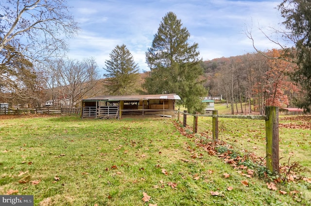 view of yard featuring an outdoor structure and a rural view