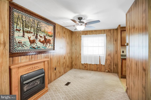 living room featuring wood walls, ceiling fan, and heating unit