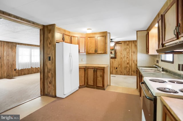 kitchen featuring wood walls, sink, white appliances, and ventilation hood