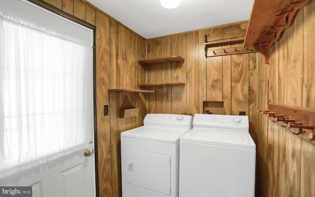 washroom with wood walls and washing machine and dryer