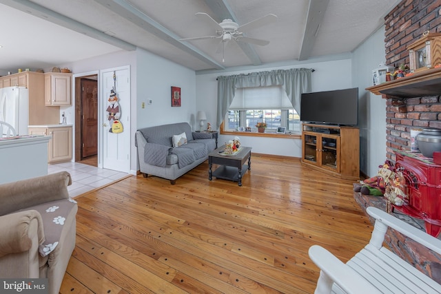 living room featuring ceiling fan, light hardwood / wood-style floors, and beam ceiling