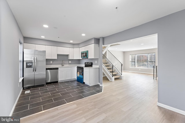 kitchen with dark wood-type flooring, white cabinetry, sink, and stainless steel appliances
