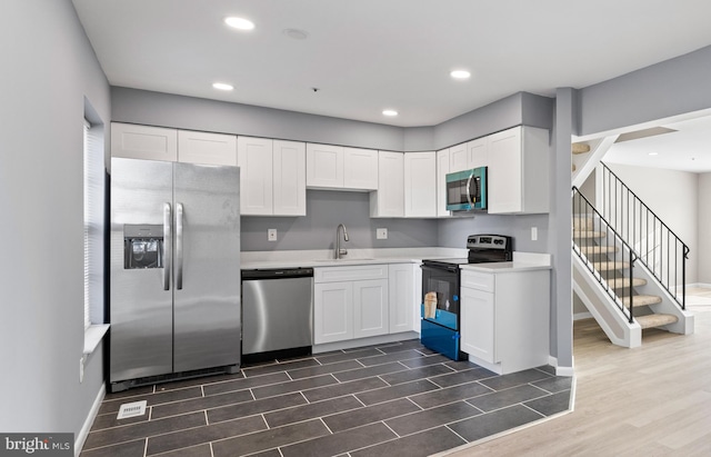 kitchen with white cabinetry, sink, dark hardwood / wood-style floors, and stainless steel appliances