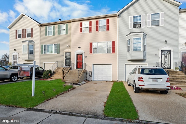 multi unit property with a garage and a front lawn