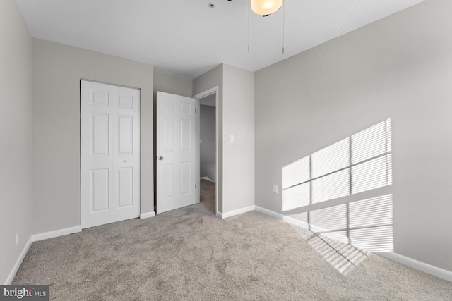 unfurnished bedroom featuring light colored carpet and a closet