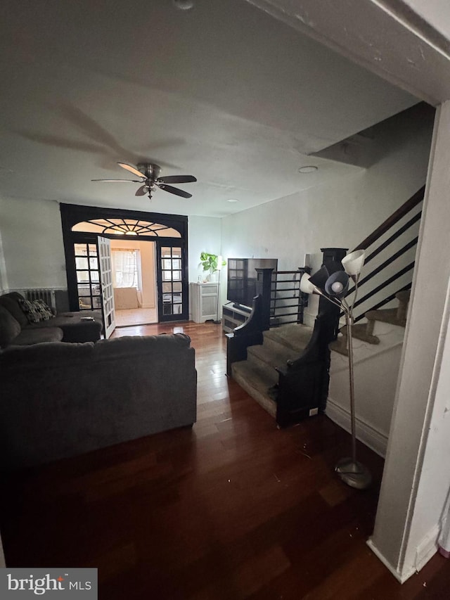 living room featuring dark wood-type flooring and ceiling fan