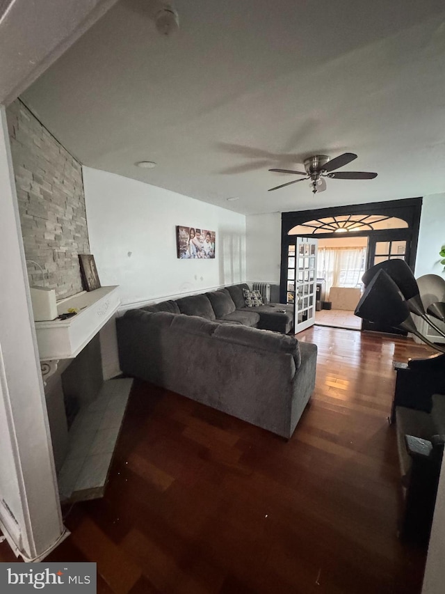 living room featuring ceiling fan and dark hardwood / wood-style floors